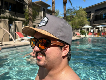 guy wearing natural cork wood hat and red wood sunglasses at pool party