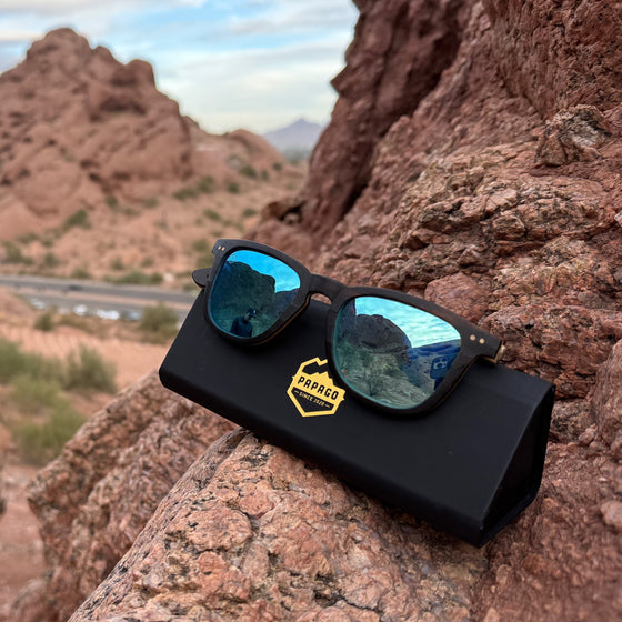 wooden wayfarer sunglasses with blue lenses on a case at papago park used for traveling to protect eyes with uv400 lenses