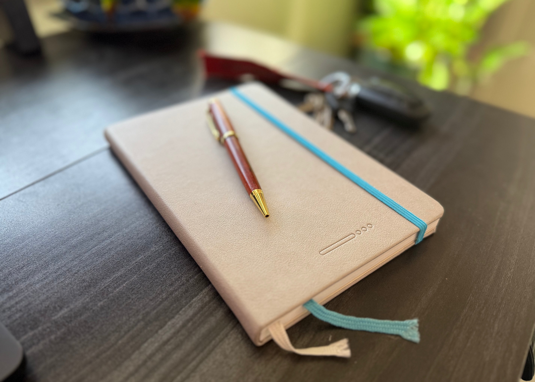 explorers journal on a desk used for writing about traveling wearing wooden sunglasses