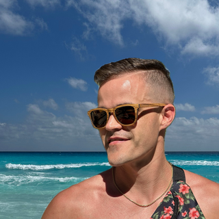 sexy guy wearing zebra wooden wayfarer sunglasses at the beach to protect eyes with uv400 lenses