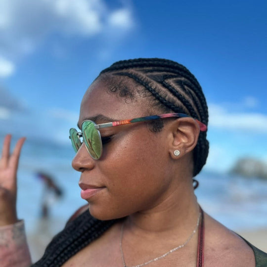 girl wearing Peacock Onofres Handmade sustainable wooden sunglasses on beach